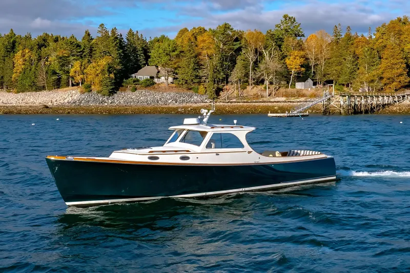 Slide: The Image of 2001 Hinckley Picnic Boat 36 Classic cruising on a scenic lake with autumn trees. - 3