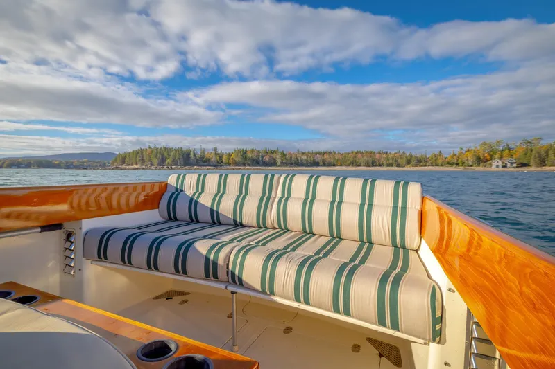 Slide: The Image of 2001 Hinckley Picnic Boat 36 Classic with striped seating, scenic water view. - 20