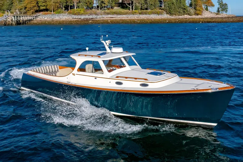 Slide: The Image of 2001 Hinckley Picnic Boat 36 Classic cruising on blue waters near a wooded shoreline. - 5