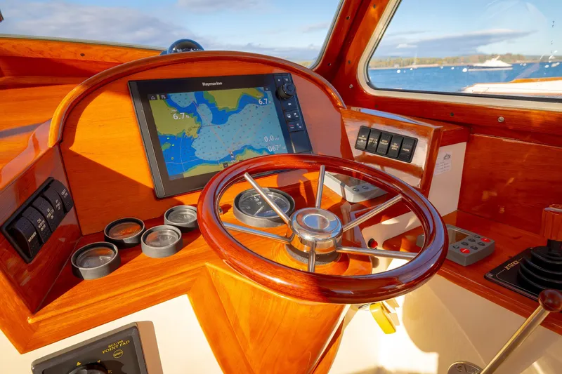 Slide: The Image of Helm of 2001 Hinckley Picnic Boat 36 Classic with navigation display and wooden steering wheel. - 26