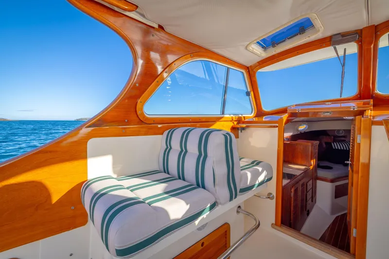 Slide: The Image of Interior of 2001 Hinckley Picnic Boat 36 Classic with striped seating and wooden finish. - 23