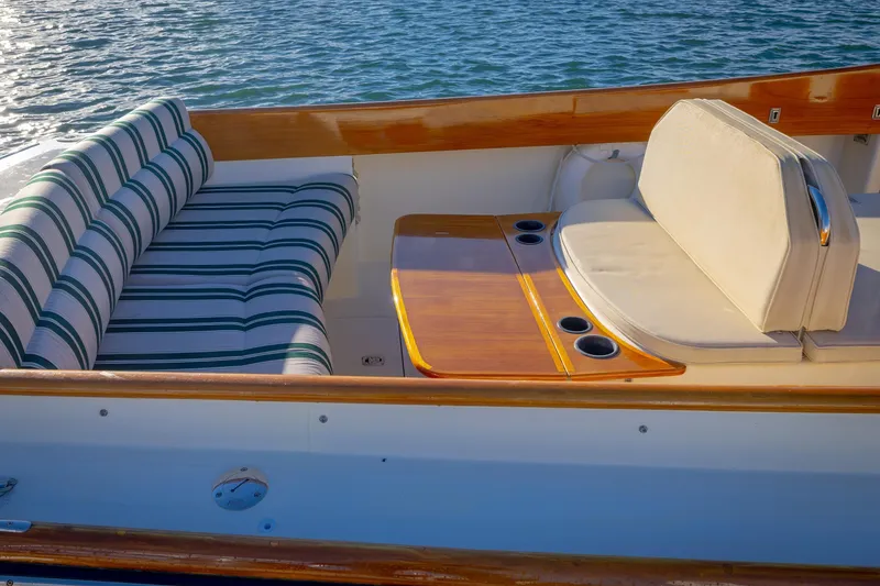 Slide: The Image of Hinckley Picnic Boat 36 Classic 2001 interior with striped seating and wooden table. - 16