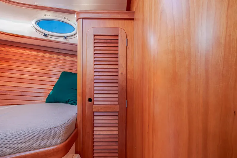 Slide: The Image of Hinckley Picnic Boat 36 Classic 2001 interior with wooden paneling and cozy cabin bed. - 34