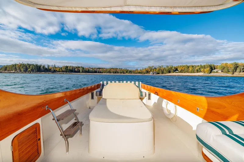 Slide: The Image of 2001 Hinckley Picnic Boat 36 Classic cruising on a scenic lake with forested shoreline. - 17