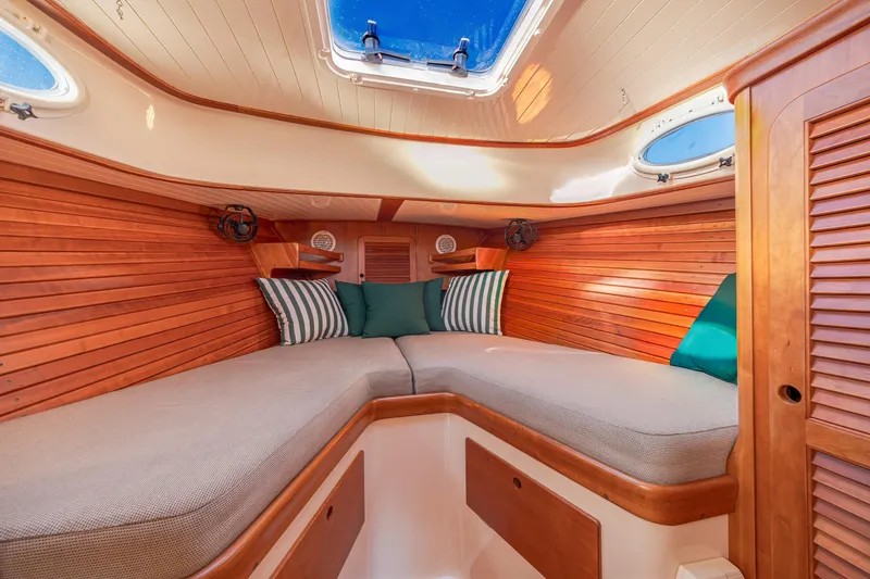 Slide: The Image of Interior of 2001 Hinckley Picnic Boat 36 Classic with cozy wooden cabin and cushions. - 32