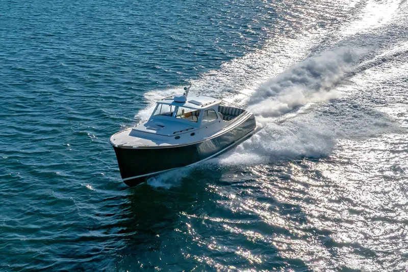 Slide: The Image of Hinckley Picnic Boat 36 Classic 2001 cruising on open water, creating a dynamic wake. - 8