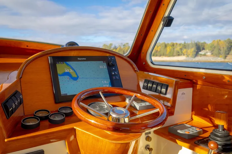 Slide: The Image of Helm of 2001 Hinckley Picnic Boat 36 Classic with navigation display and wooden steering wheel. - 25