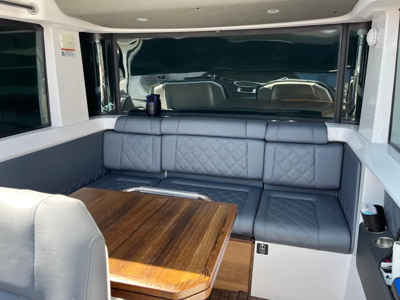 Slide: The Image of Interior of 2020 Axopar 37 XC with gray seating and wooden table. - 24