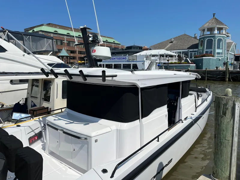 Slide: The Image of 2020 Axopar 37 XC boat docked at a marina with waterfront buildings. - 34