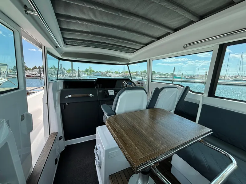 Slide: The Image of Interior of 2020 Axopar 37 XC boat with seating and table, docked at marina. - 15