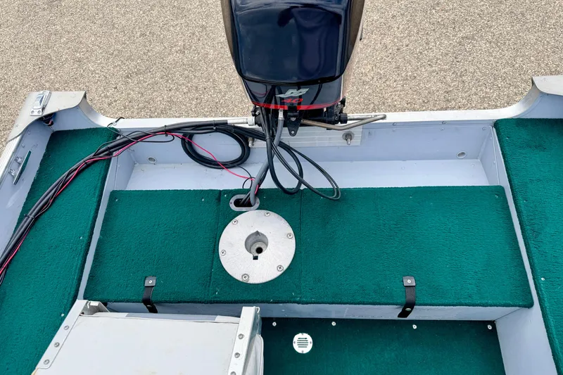 Slide: The Image of 2002 Lund 1650 Rebel SS boat interior with green carpet and motor. - 16