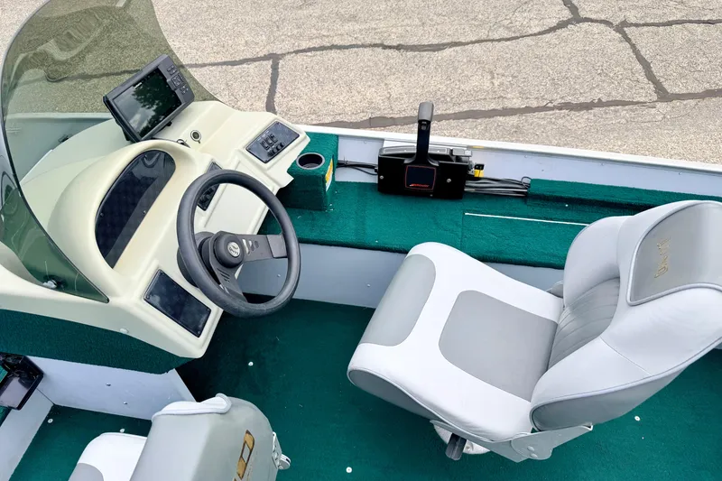 Slide: The Image of 2002 Lund 1650 Rebel SS boat interior with steering wheel, seat, and control panel. - 18