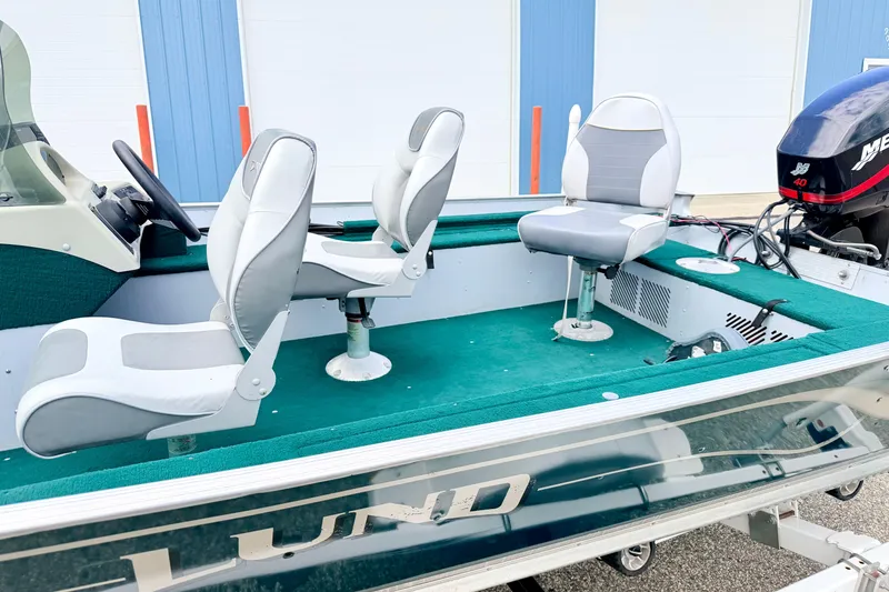 Slide: The Image of 2002 Lund 1650 Rebel SS boat interior with green carpet and swivel seats. - 57