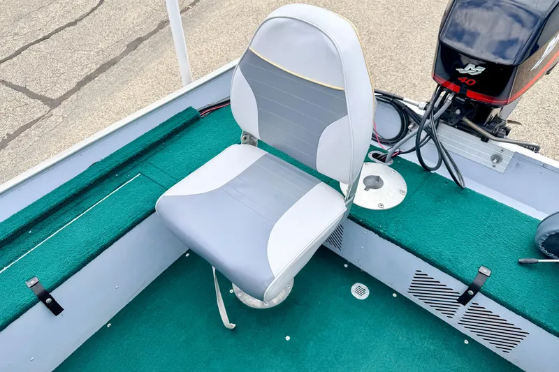 Slide: The Image of 2002 Lund 1650 Rebel SS boat interior with green carpet and swivel seat. - 19