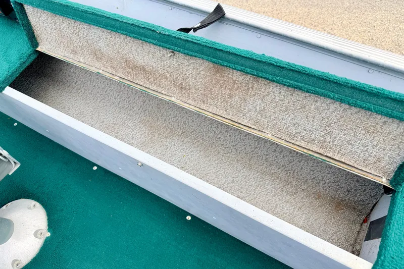 Slide: The Image of Open storage compartment in 2002 Lund 1650 Rebel SS boat with green carpet interior. - 27