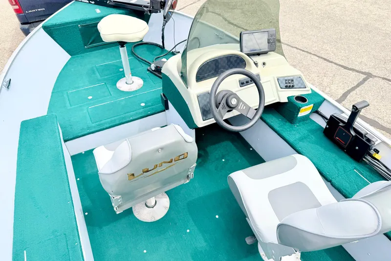 Slide: The Image of 2002 Lund 1650 Rebel SS boat interior with green carpet and steering console. - 53