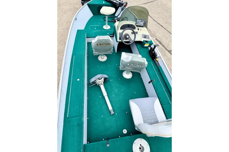 Slide: The Image of 2002 Lund 1650 Rebel SS boat interior with green carpet and seating. - 17