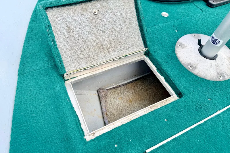 Slide: The Image of Open storage compartment on 2002 Lund 1650 Rebel SS boat with green carpeted deck. - 42