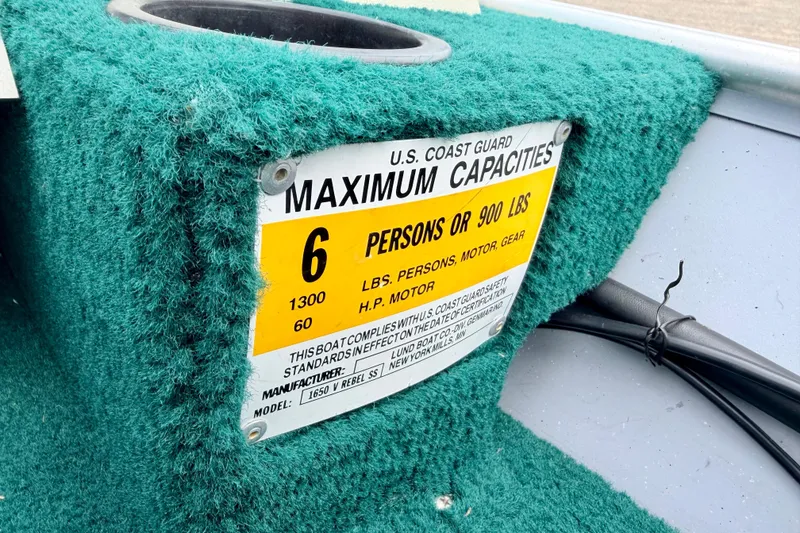 Slide: The Image of 2002 Lund 1650 Rebel SS boat capacity label, green carpet, U.S. Coast Guard compliance. - 25