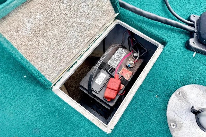 Slide: The Image of Battery compartment of a 2002 Lund 1650 Rebel SS boat, featuring teal carpeting. - 46