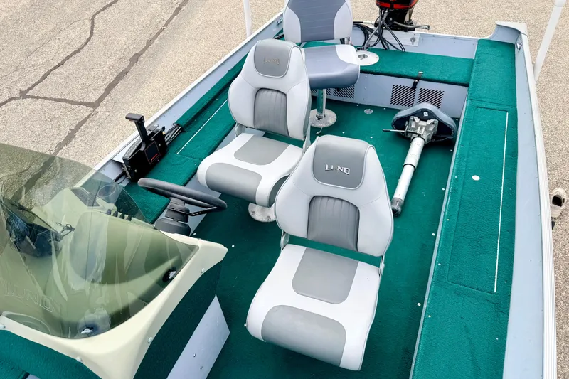 Slide: The Image of 2002 Lund 1650 Rebel SS boat interior with green carpet and two gray seats. - 35