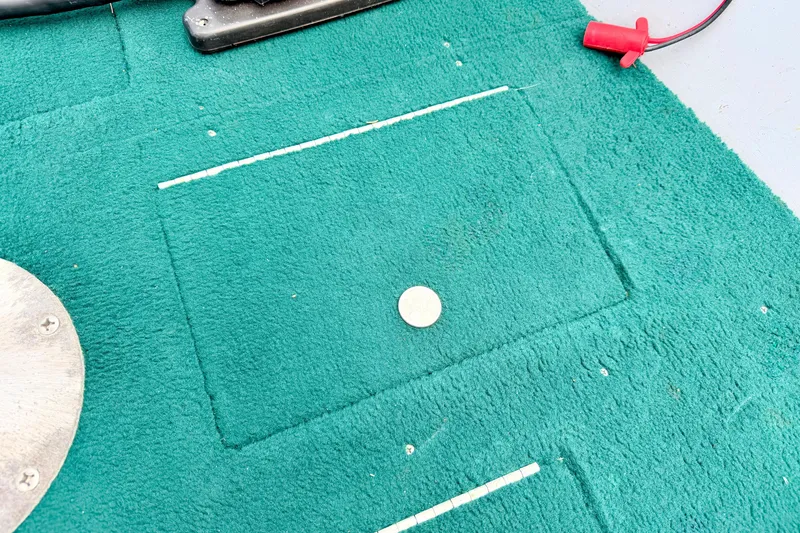 Slide: The Image of Green carpeted deck of a 2002 Lund 1650 Rebel SS boat with a coin. - 43