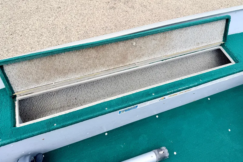 Slide: The Image of Open storage compartment in 2002 Lund 1650 Rebel SS boat with green carpet interior. - 34
