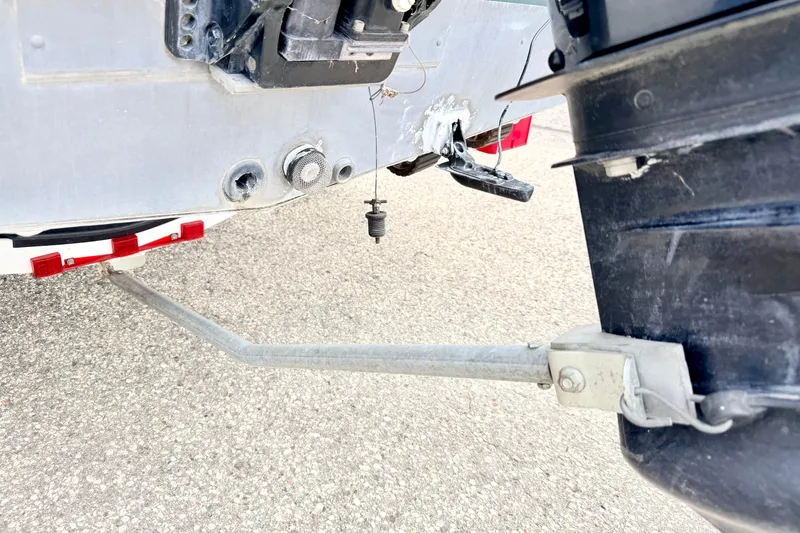 Slide: The Image of Rear view of a 2002 Lund 1650 Rebel SS boat showing motor and trailer hitch. - 54
