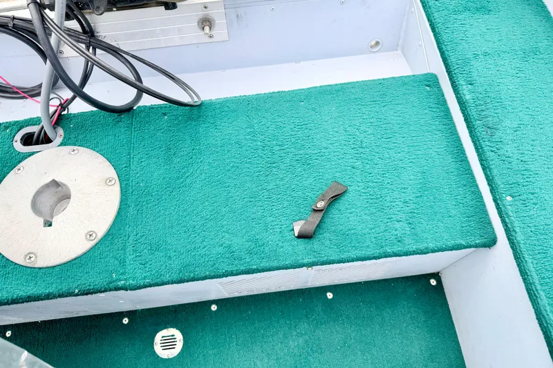 Slide: The Image of Interior of 2002 Lund 1650 Rebel SS boat with green carpet and metal fittings. - 29