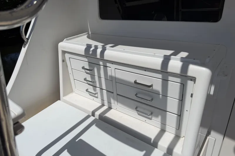 Slide: The Image of Storage drawers on a 2000 Cabo 35 Flybridge boat, featuring sleek white design. - 52
