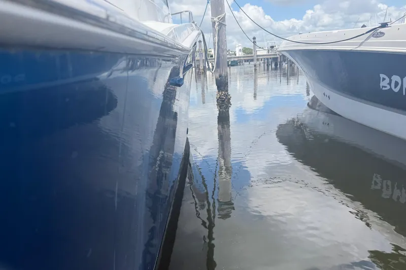 Slide: The Image of Two boats docked in calm water, featuring a 2000 Cabo 35 Flybridge. - 25