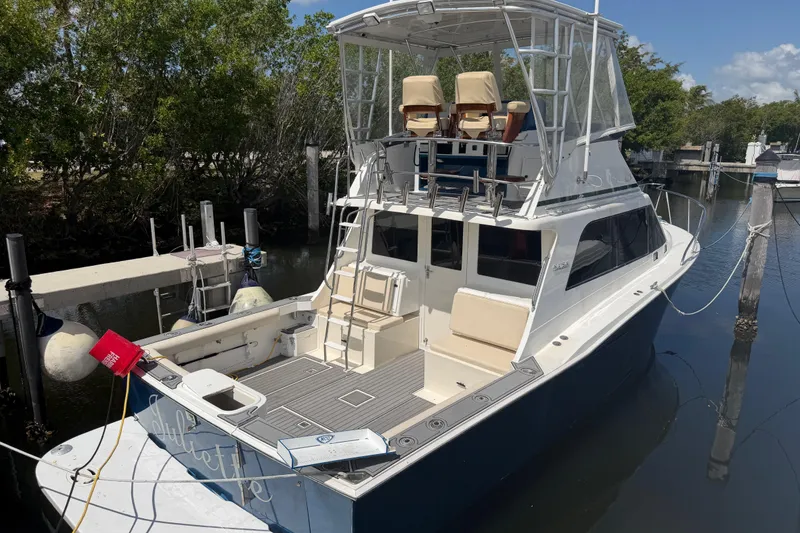 Slide: The Image of 2000 Cabo 35 Flybridge boat docked, featuring spacious deck and flybridge seating. - 1