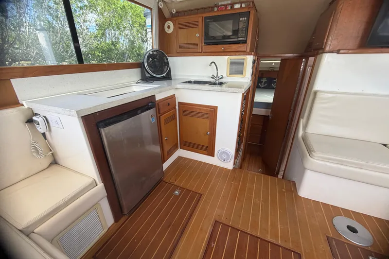 Slide: The Image of Interior of 2000 Cabo 35 Flybridge boat with kitchenette and seating area. - 64