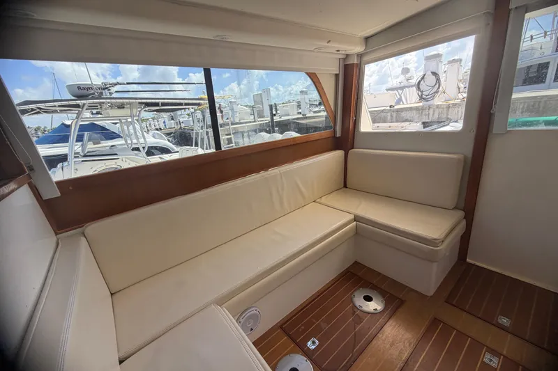 Slide: The Image of Interior of 2000 Cabo 35 Flybridge with cream seating and marina view. - 58