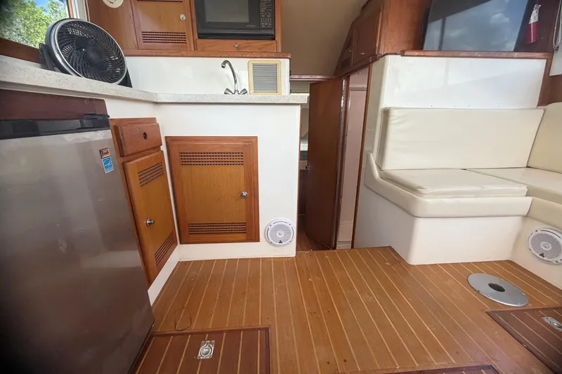 Slide: The Image of Interior of 2000 Cabo 35 Flybridge with wood flooring, seating, and kitchenette area. - 75