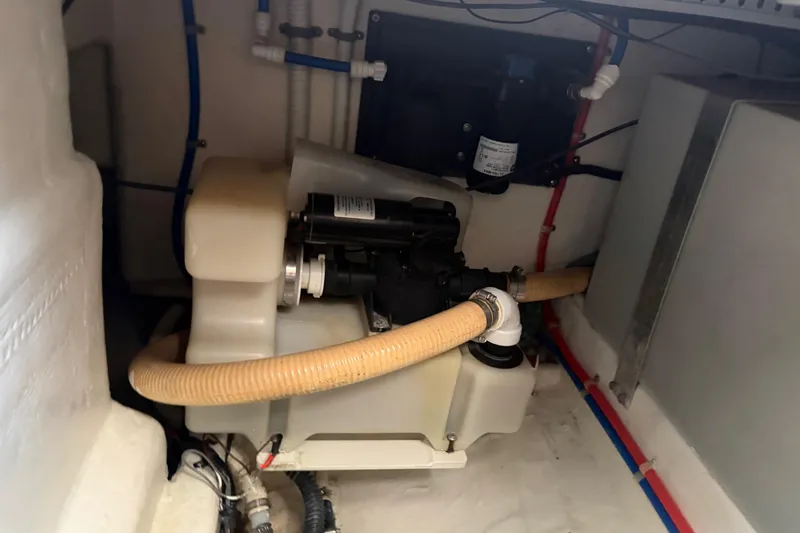 Slide: The Image of Engine compartment of a 2000 Cabo 35 Flybridge boat, featuring hoses and mechanical components. - 103