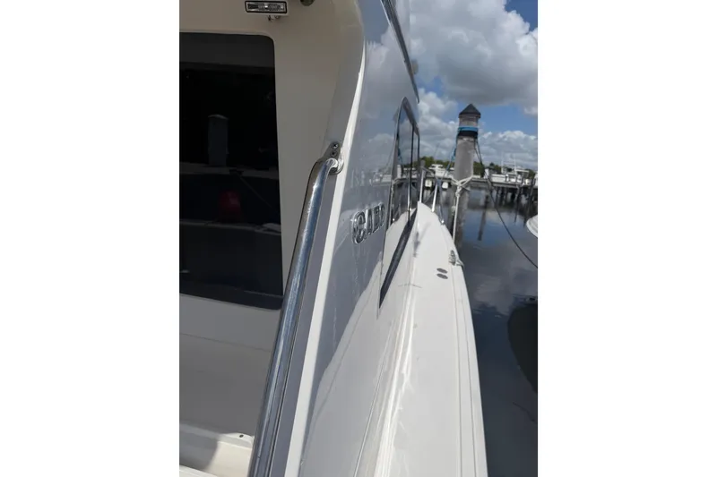 Slide: The Image of Side view of a 2000 Cabo 35 Flybridge boat docked under a cloudy sky. - 34