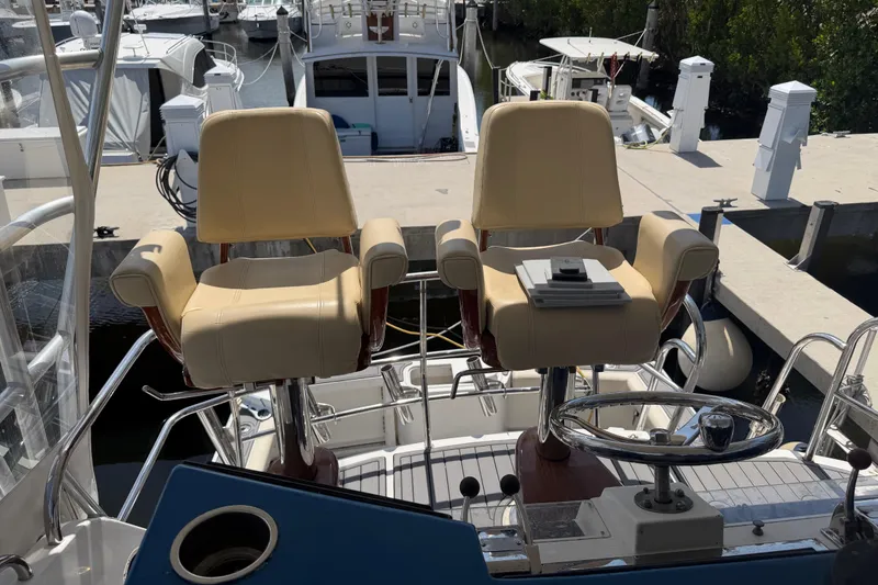 Slide: The Image of Flybridge of 2000 Cabo 35 with dual helm chairs and steering wheel at marina. - 20