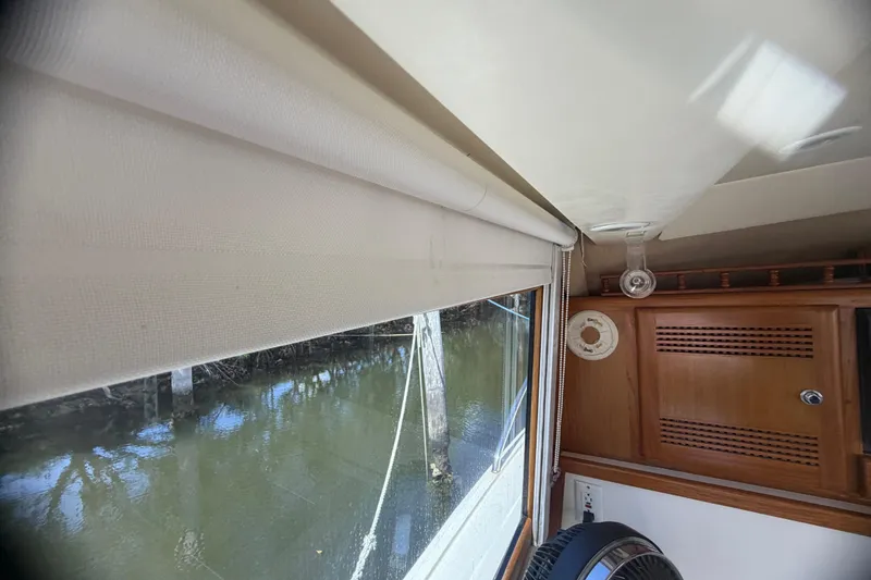 Slide: The Image of Interior view of a 2000 Cabo 35 Flybridge boat, featuring a window with a blind. - 68
