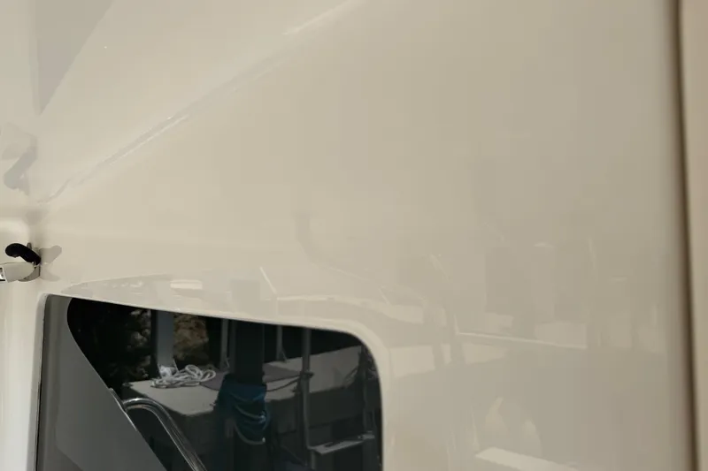 Slide: The Image of Close-up of a 2000 Cabo 35 Flybridge boat's exterior, showcasing sleek design and window detail. - 37