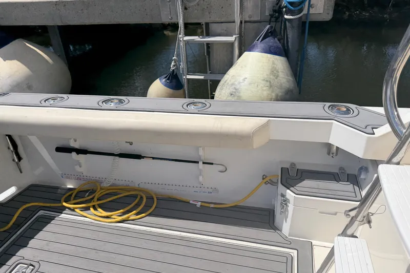 Slide: The Image of Cabo 35 Flybridge 2000 boat deck with fishing rod holders and docked fenders. - 46