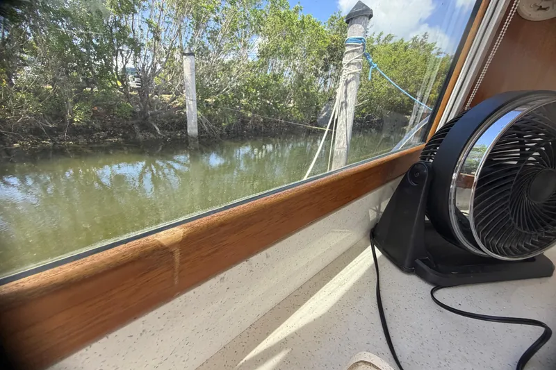 Slide: The Image of Interior view from a 2000 Cabo 35 Flybridge boat, showing a window and fan. - 70