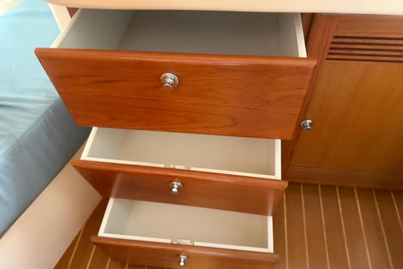 Slide: The Image of Open wooden drawers inside a 2000 Cabo 35 Flybridge boat interior. - 88