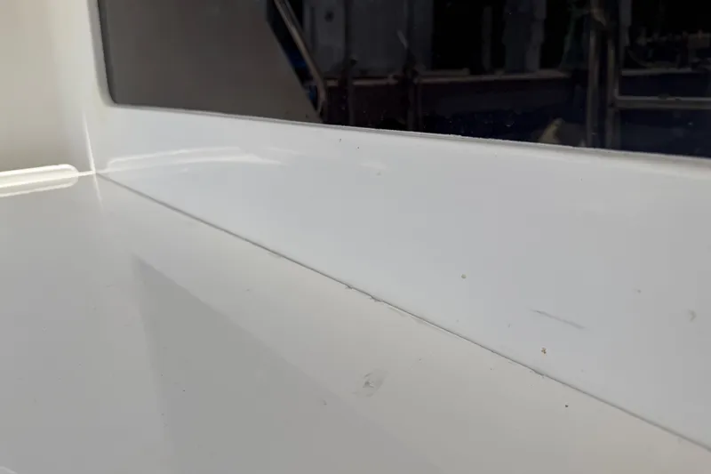 Slide: The Image of Close-up of a 2000 Cabo 35 Flybridge boat's sleek white surface and window. - 36