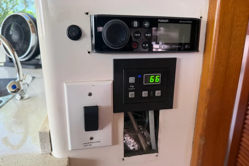 Slide: The Image of Control panel on a 2000 Cabo 35 Flybridge boat, featuring audio and temperature settings. - 77