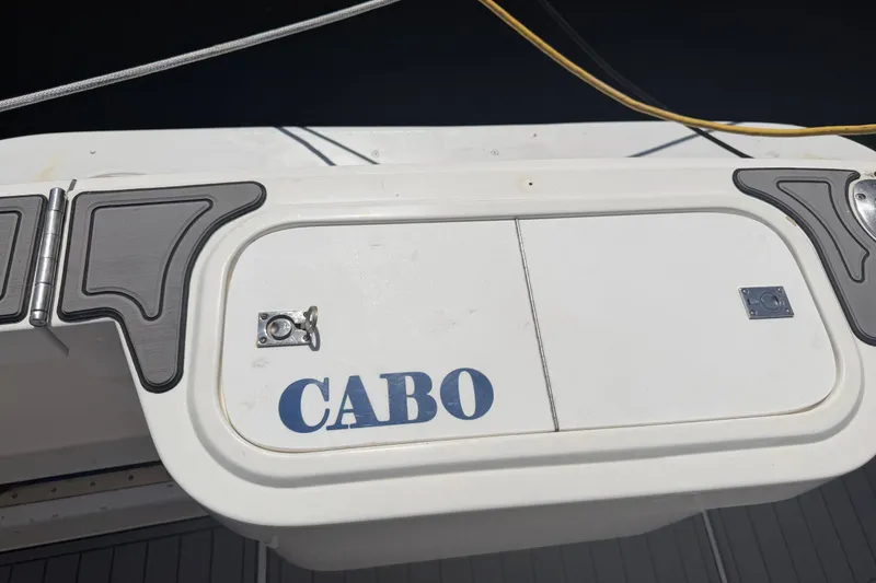 Slide: The Image of Cabo 35 Flybridge 2000 boat deck with storage compartment and logo. - 48