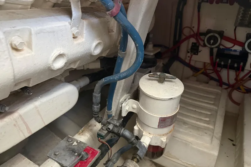 Slide: The Image of Engine room of 2000 Cabo 35 Flybridge with visible fuel filter and wiring. - 98