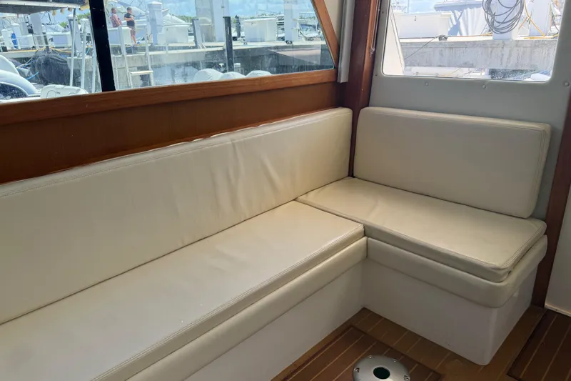 Slide: The Image of Interior seating area of a 2000 Cabo 35 Flybridge boat with cream cushions. - 57