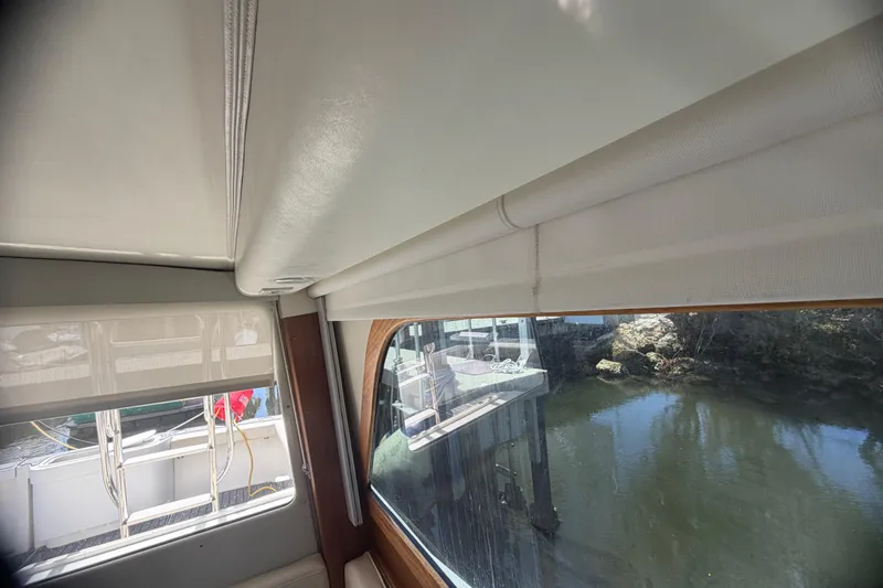 Slide: The Image of Interior view of a 2000 Cabo 35 Flybridge boat with window shades and water outside. - 67