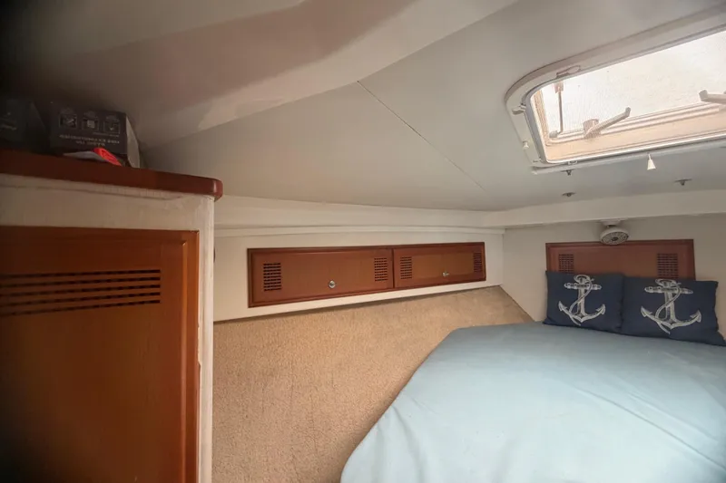 Slide: The Image of Cozy cabin interior of 2000 Cabo 35 Flybridge with nautical-themed pillows and overhead hatch. - 84